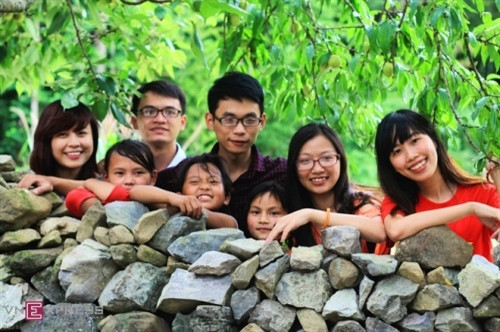 在桃树下，山区小孩与游客开心玩耍（图片来源：vnexpress.net）