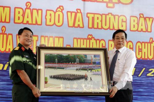 越南信息传媒部部长阮北山向东南部武装力量博物馆代表赠送越南国庆70周年庆典的图片。（图片来源：越通社）