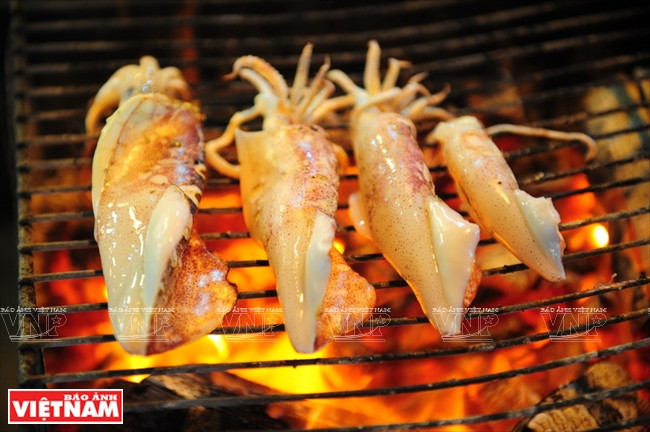 游客品尝新鲜海产。伯玉 摄