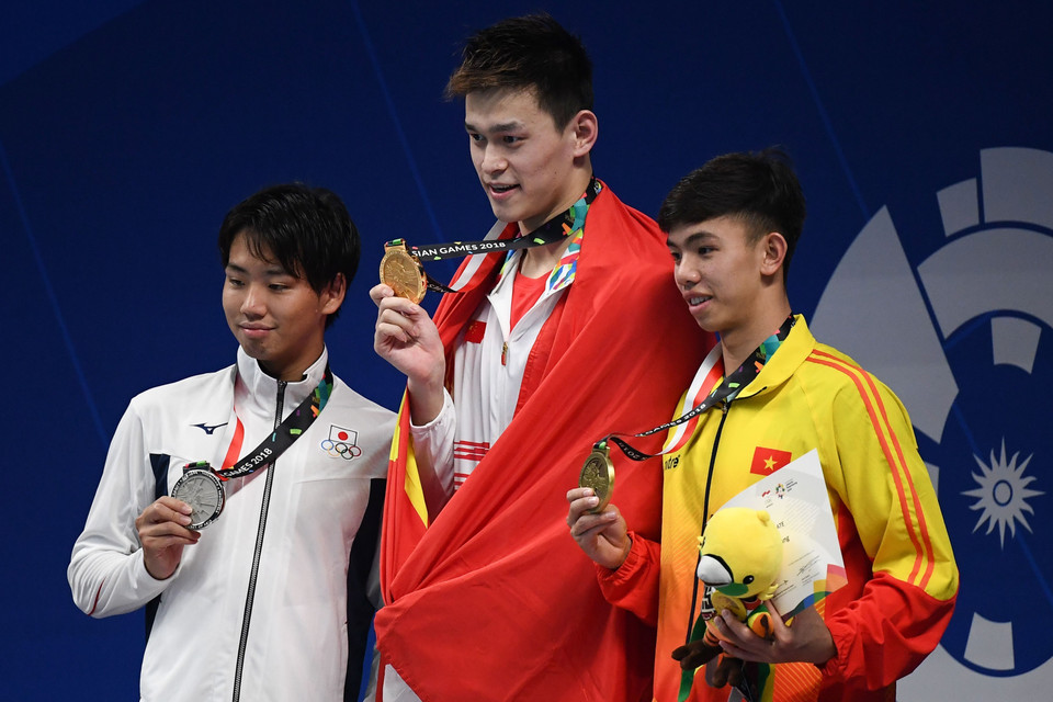 游泳运动员阮辉煌（右一）获得男子800米自由泳铜牌。图自越通社