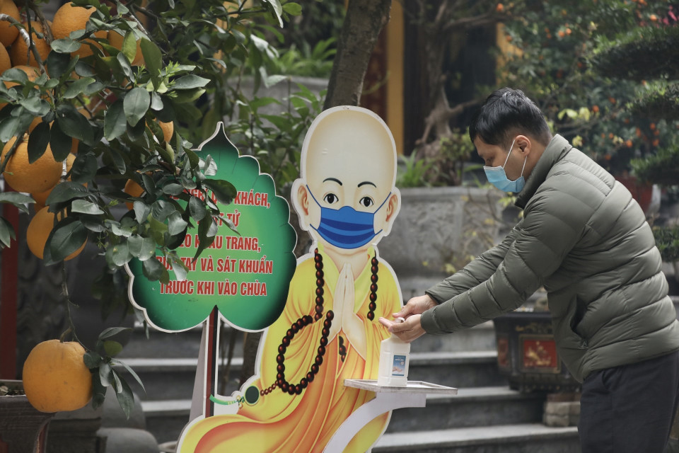 由于遭受新冠肺炎疫情的影响，人们前往寺庙拜佛时都严格遵守各项新冠肺炎疫情防控措施。图自越通社