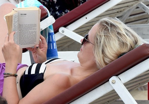 外国游客躺在海边躺椅上看书（图片来源：人民军队报）