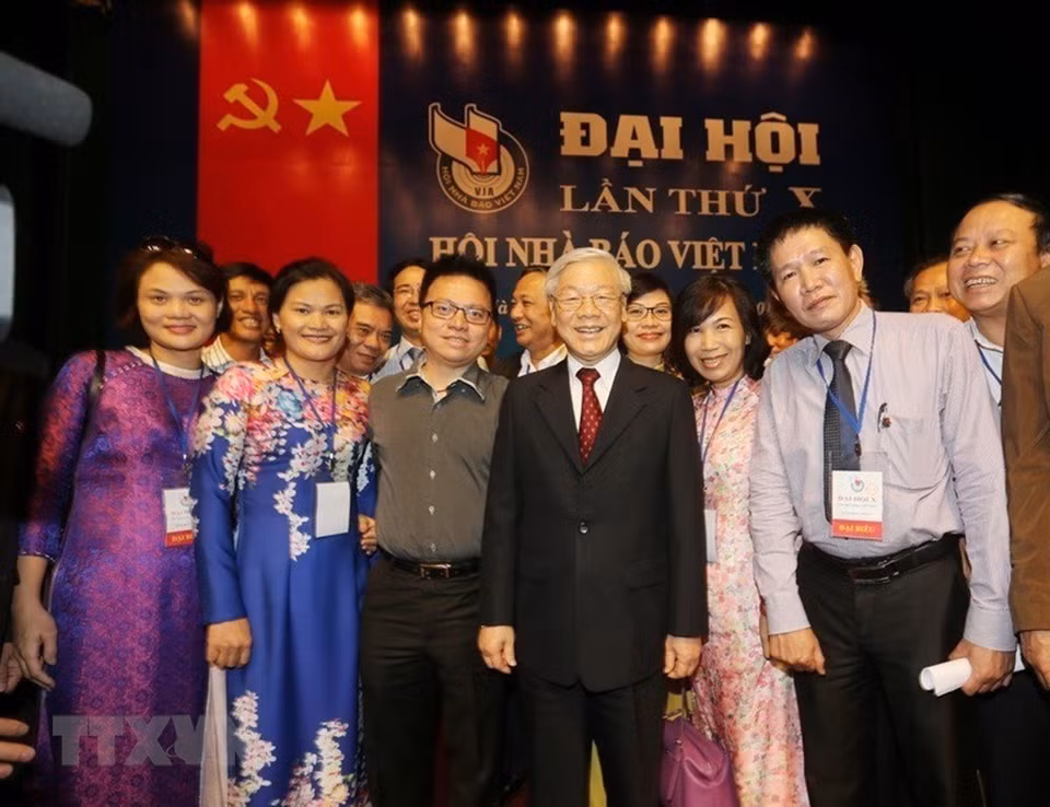 越共中央总书记阮富仲与于2015年8月9日出席2015 —— 2020 年任期越南新闻工作者协会第十次全国代表大会的越通社记者合影。越通社记者 智勇 摄