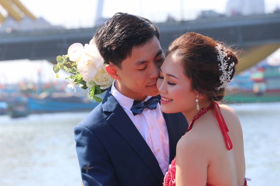 在“爱情桥”上拍婚照的一对情侣。图自越通社