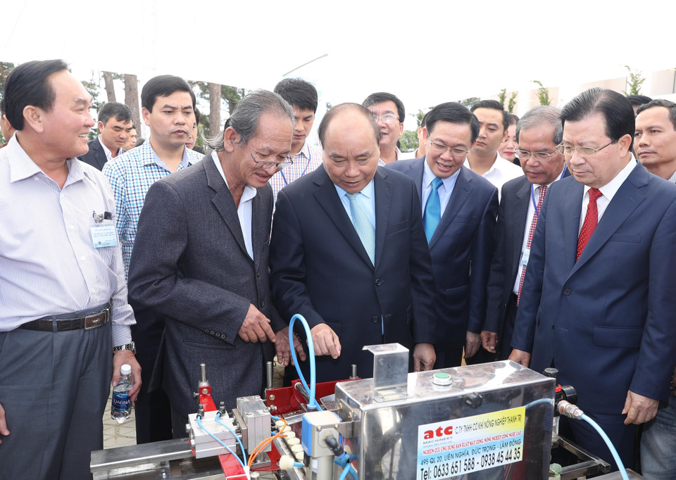 阮春福同各位代表参观在会上设立的展位。越通社记者 统一 摄