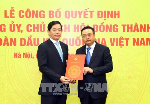  越共中央委员、中央直属企业党委书记范曰青向越南油气集团党委书记兼集团董事会主席陈士青颁发任命决定书。（图片来源：越通社）