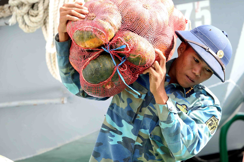 146旅战士一起将货品搬到到船上。越通社记者 邓军 摄