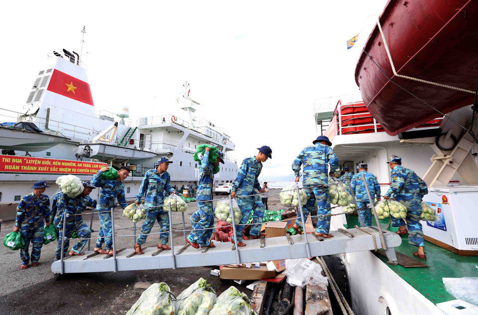 146旅战士一起将货品搬到船上。越通社记者 邓军 摄