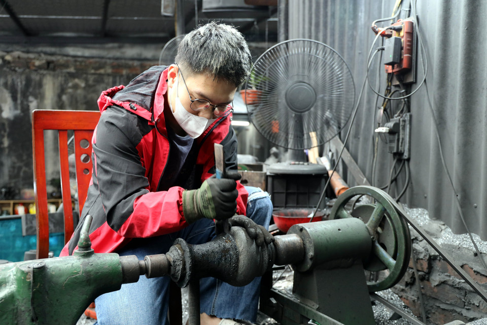 决平煤炭美术制作厂的工匠们纯手工雕刻花瓶。图自越通社