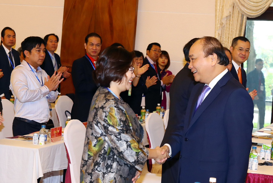 越南政府总理阮春福与出席2018年富安省投资促进会的代表亲切握手。越通社记者 统一 摄