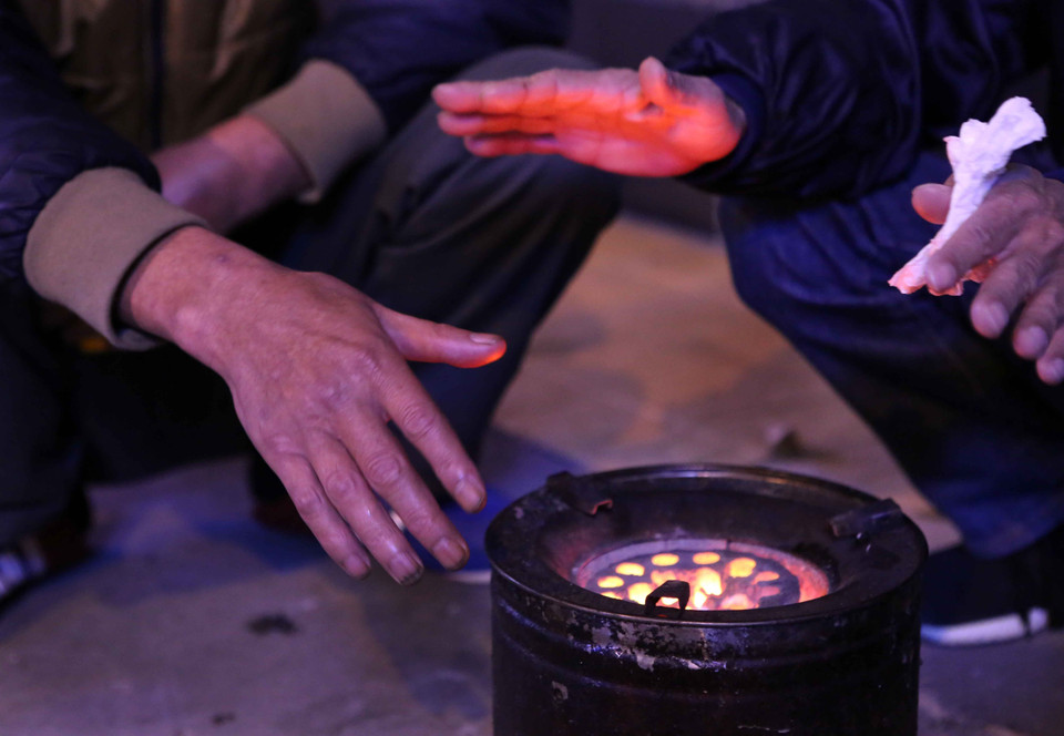 无家可归者在路边使用煤炉取暖。越通社记者 仲达 摄