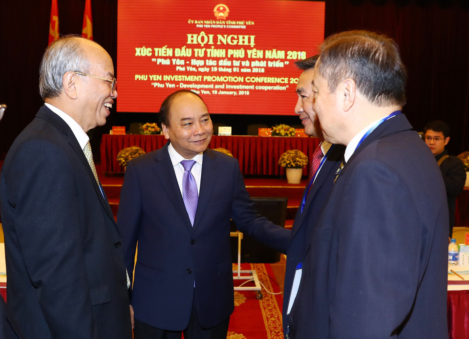  越南政府总理阮春福与出席2018年富安省投资促进会的代表亲切交谈。越通社记者 统一 摄
