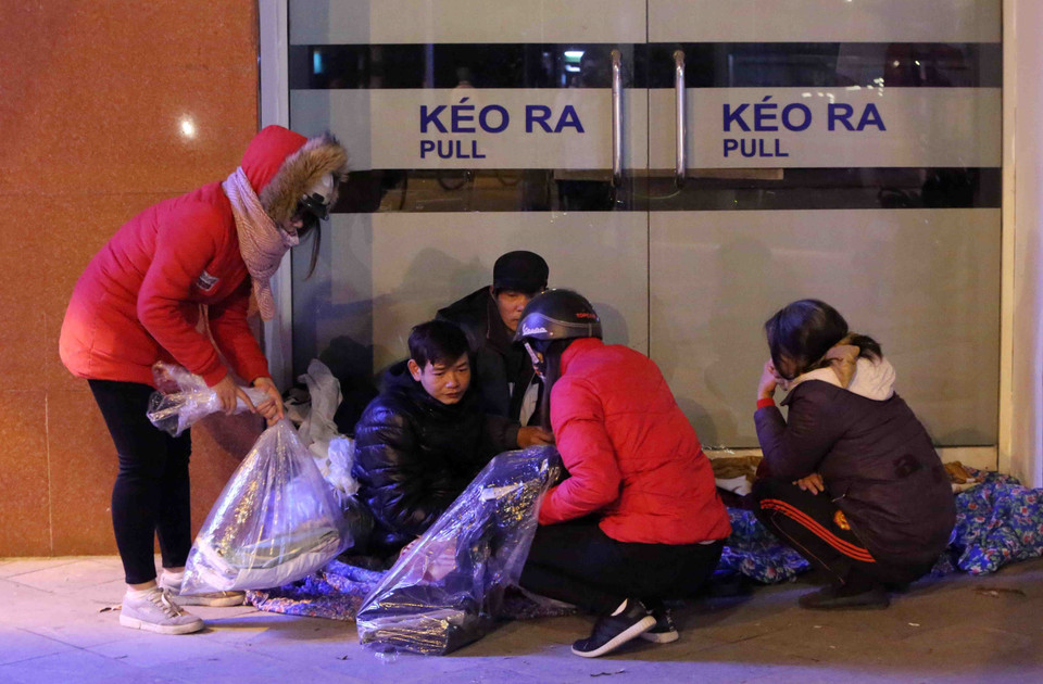 一群志愿者向一无家可归者提供御寒物品。越通社记者 仲达 摄