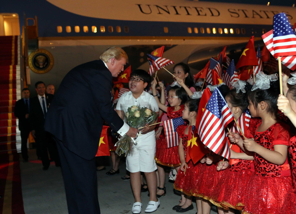 特朗普在欢迎仪式上向一名儿童送花。（图片来源：越通社）