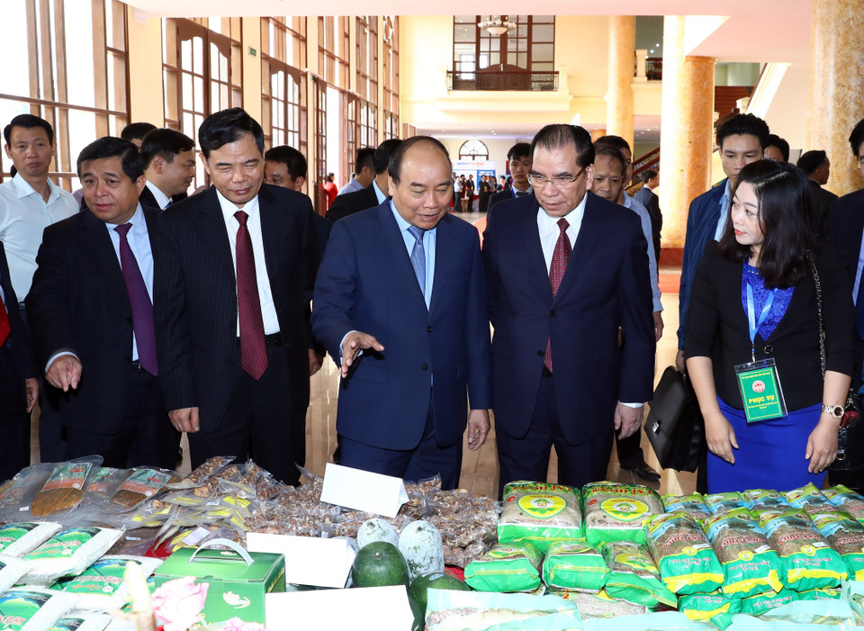 阮春福与各代表参观各展位上展示的产品。（图片来源：越通社）