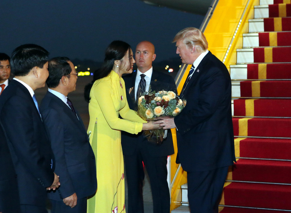 一名河给姑娘向特朗普送花。（图片来源：越通社）