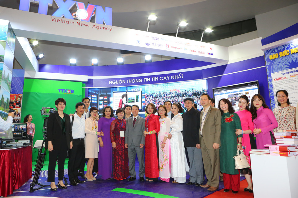 越通社社长阮德利和本社记者、编辑员和技术员在越南展位合影。图自越通社