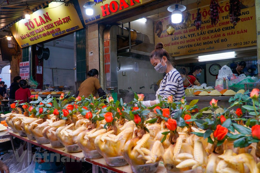 河内市还剑郡的筏行市场和嘉鱼街市的一个著名且最具特色的祭品之一是叼玫瑰鸡。像春节期间一样，元宵节要用的祭品中，叼玫瑰鸡是最畅销的。在此期间，每家商店大概都能卖出几百只公鸡，就连顾客也得争先恐后地挑选自己最得意并觉得最好的叼玫瑰鸡。（图自Vietnam+）