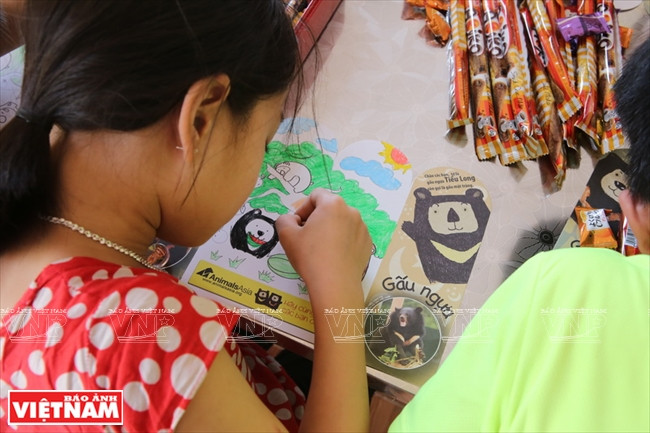 小朋友对三岛熊类救护中心的宣传活动颇感兴趣。越南画报记者 功达 摄