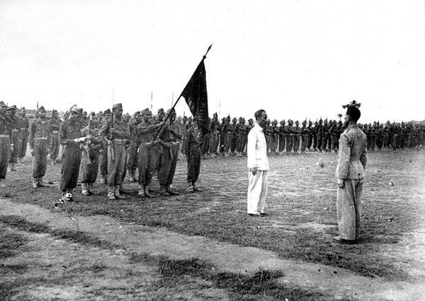 1946年5月26日，胡志明主席走访陈国俊武备学校并向该校赠送绣着“忠于国、孝于民”六个金字的旗帜。图自越通社