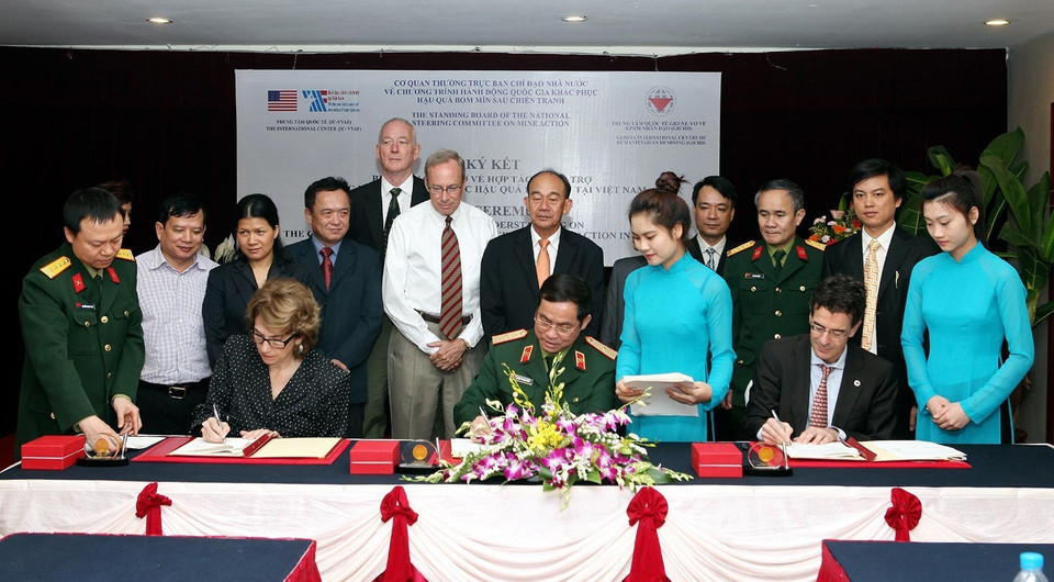 2013年3月27日，处理战后遗留炸弹地雷后果国家行动计划指导委员会（简称504号指导委员会）、日内瓦国际人道主义排雷中心(GICHD)、克服越南战后遗留地雷和炸弹后果国际中心(IC-VVAF)共同签署2012-2015年阶段协助越南展开战后遗留地雷炸弹后果合作备忘录。图自越通社