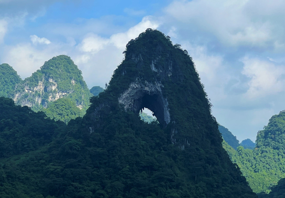 来到高平省茶岭县国瓒社本名村，游客可以欣赏高平山水地质公园汤亨湖群神眼山的美景。周围环绕着绿草覆盖的广阔山谷，一片荒凉又寂静，马群悠闲地吃着草。图自越通社