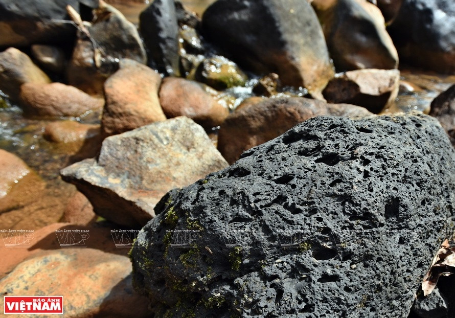 瀑布脚下的熔岩石是数百万年前火山喷发的痕迹。图片来源：越通社