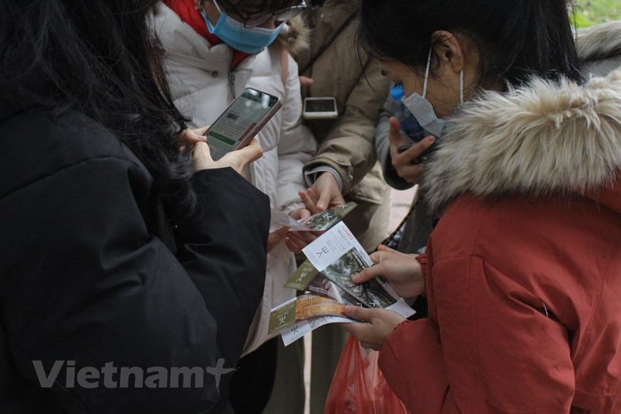 许多家庭让孩子去求字，意在让孩子了解该习俗的意义并祈求好运。在河内文庙国子监胡文区，小朋友们专注于书法家每个笔画。求字活动体现求字者对新一年的愿望。为了防疫安全，书法家们均带上口罩，在河内文庙国子监胡文区的书法家正专心写字。图自Vietnam+