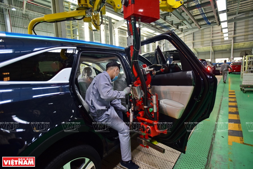 员工们使用机械臂组装车门。图片来源：越通社