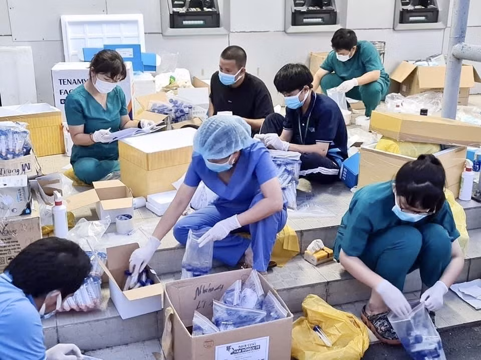 胡志明市国家大学医药大学志愿者在首德市一号玲忠加工出口区采样检测区对样本进行分类。图自越通社