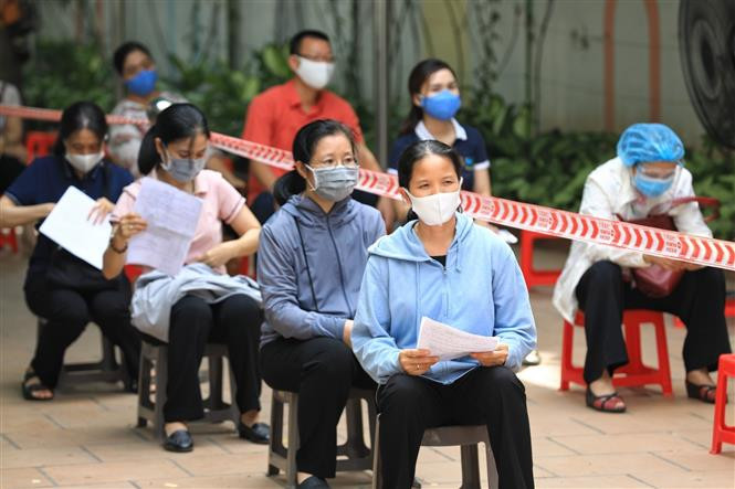 还剑郡居民排队等候，保持安全距离。图片来源：越通社