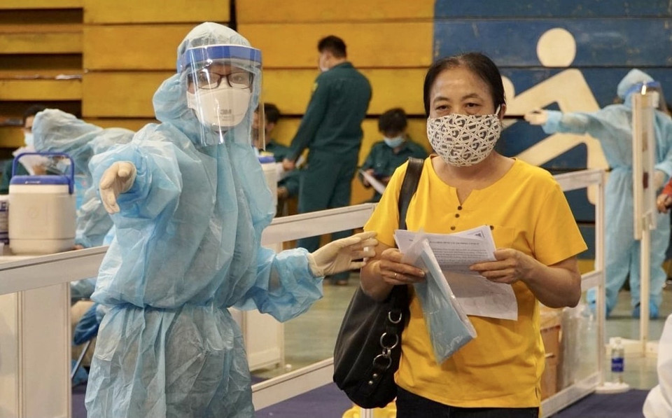 医科大学学生在第11郡富寿运动场引导居民办理疫苗接种手续。图自越通社