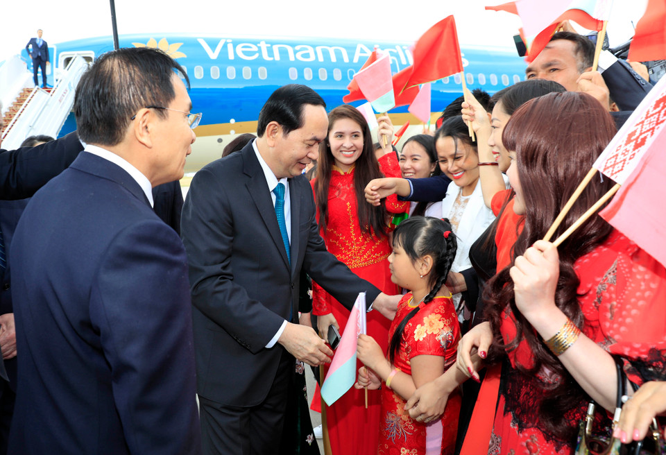 越南驻白俄罗斯大使馆干部、旅居白俄罗斯越南人代表和在白俄罗斯学习的留学生代表等热烈欢迎越南国家主席陈大光和夫人及越南高级代表团访问白俄罗斯。（图片来源：越通社）