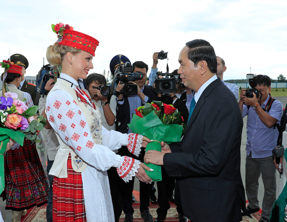 身穿传统服饰的白俄罗斯姑娘按照当地迎接最尊贵客人的礼节向陈大光主席和夫人献上象征热情友好的面包和盐。（图片来源：越通社）