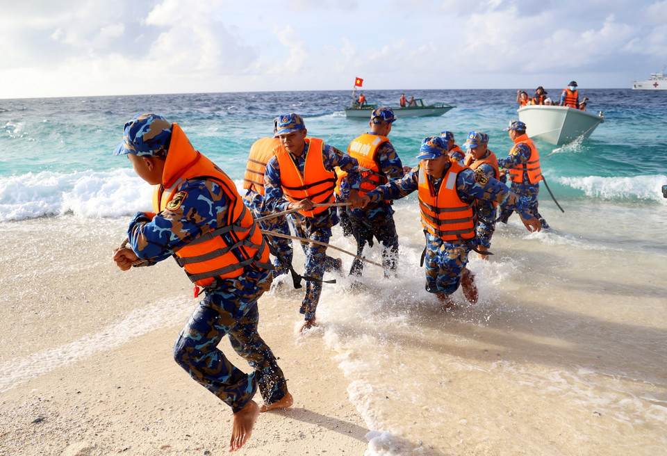 安邦岛干部战士把船推上岸。图自越通社