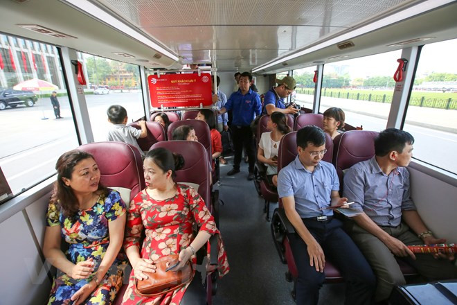 乘坐双层观光巴车的河内市居民。（图片来源：越通社）