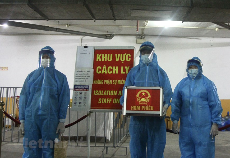 5月23日上午7时整，越南第十五届国会代表和2021-2026年各级人民议会代表在全国约八万个投票站进行。在各选区开展选举工作的同时，选举小组将投票箱送到河内芒青酒店。这里有67名外籍隔离人员接受隔离，同时有4名越南籍公民为其服务。图自Vietnam+