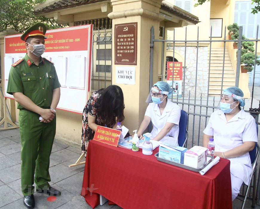 其后，近200名武装力量战士进行投票。组委会在选区放置杀菌剂、口罩，实施社交距离，并要求人们遵守5K口号，确保防疫要求。当前疫情防控形势仍然复杂严峻，但第十五届国会和2021-2026年任期各级人民议会换届选举筹备工作依法依规有序进行。图自Vietnam+