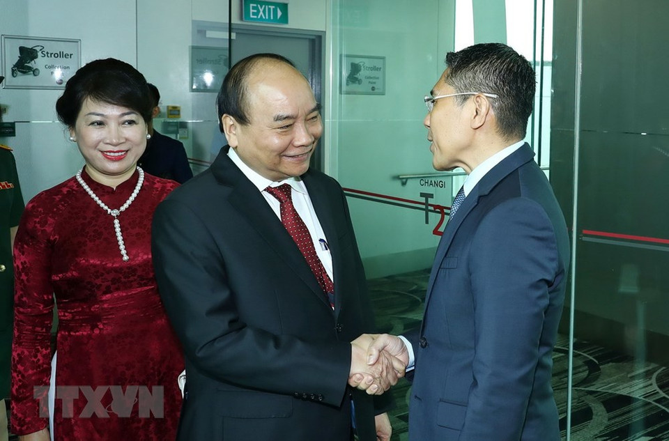 新加坡国务卿和外交部代表同越南驻新加坡大使馆干部和工作人员到机场迎接阮春福一行。图自越通社