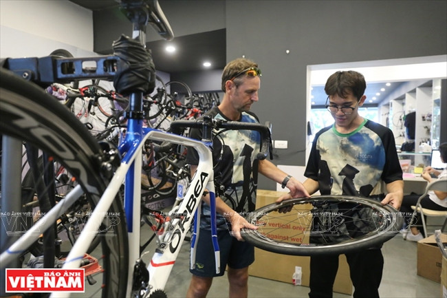 理査德和店员检查客户的车胎。越南画报记者 碧云/庆龙