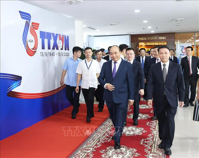 政府总理阮春福（左）和越通社社长阮德利。图自越通社