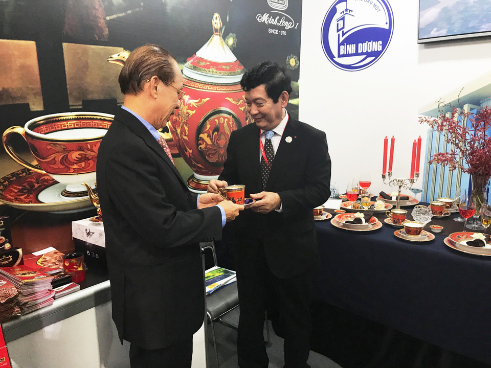 越南文化体育旅游部副部长黄永爱（左）参观明隆展位。（图片来源：越通社）