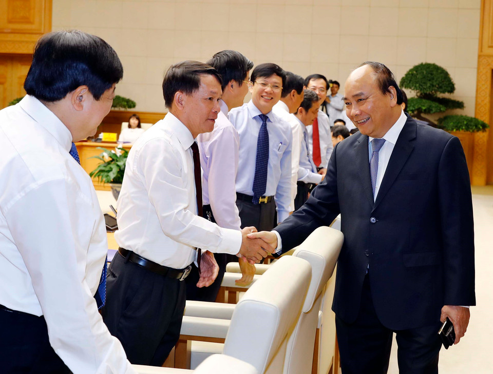  越南政府总理阮春福与越通社社长阮德利亲切握手。越通社记者 统一 摄