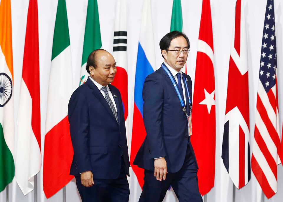  越南政府总理阮春福率团出席峰会开幕式。6月28日，日本首相安倍晋三为前来参加峰会的各代表团团长举行欢迎仪式。 越通社记者 统一 摄