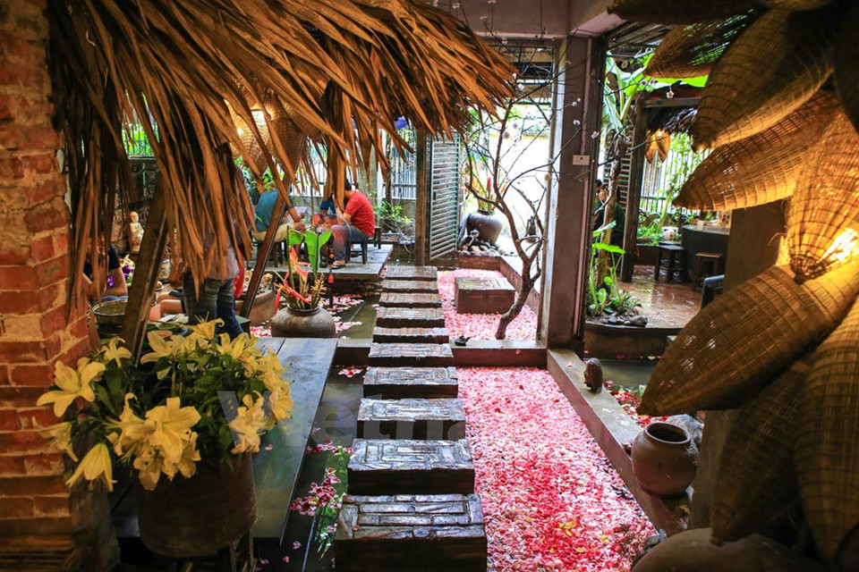 店主安原分享说：放满着莲花瓣的小水池与旁边的竹制桌椅相结合让食客们回想到一个宁静简朴的乡村 。（图片来源：越通社）