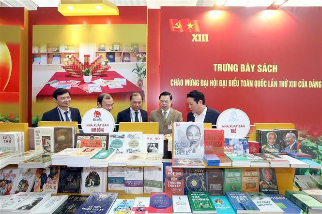 与会代表在展示空间观看资料图片。图自越通社