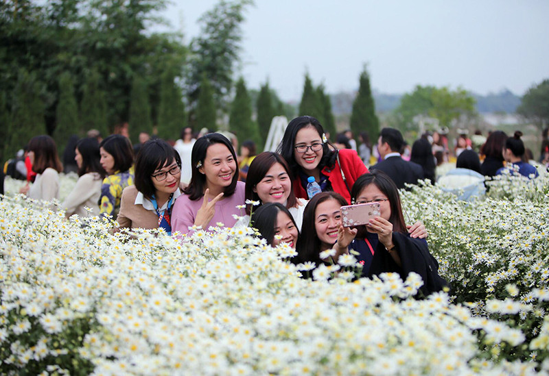 一为农民在首都街上卖花。（图片来源：人民报网）