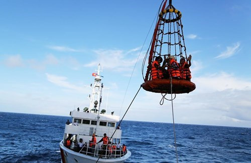工作团乘坐起重系统登上高脚屋。（图片来源：越南《人民军队报》）
