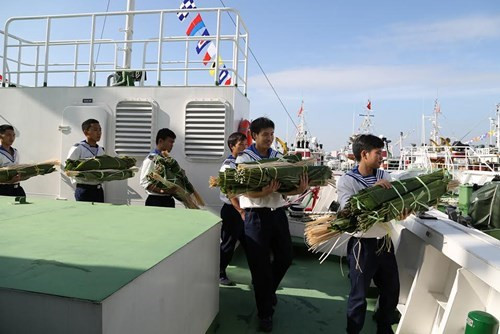 将柊叶送上船。（图片来源：越南《人民军队报》）