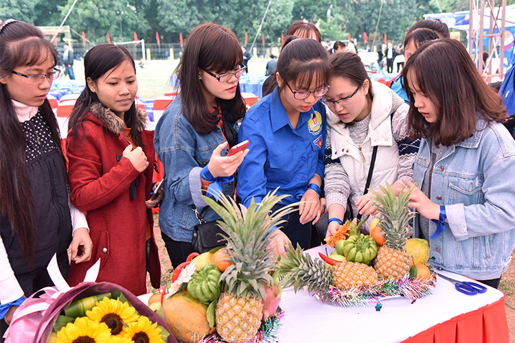 学生们一起学习摆放春节“五果盆”方式。（图片来源：越南《人民报》）